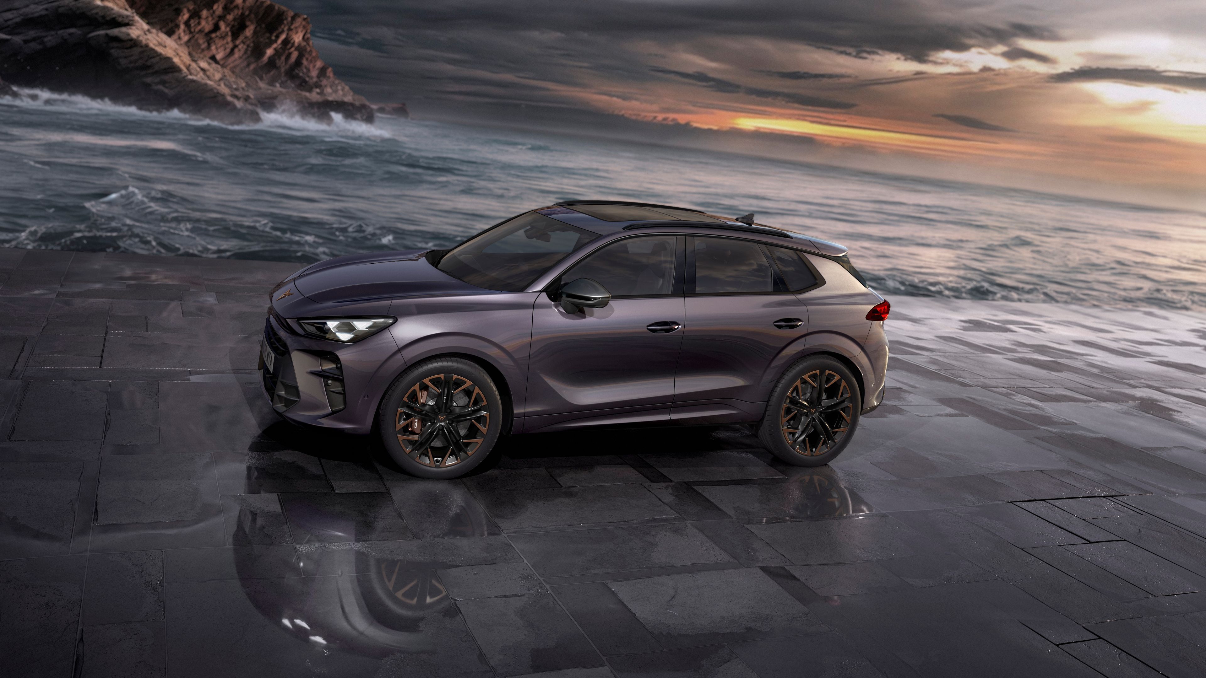 SUV Microhíbrido CUPRA Terramar visto de perfil frente al mar, con paisaje rocoso y cielo nublado al atardecer.